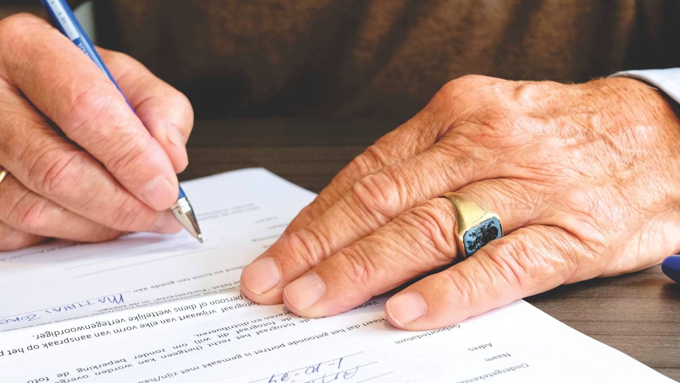 Elderly investor signing documents
